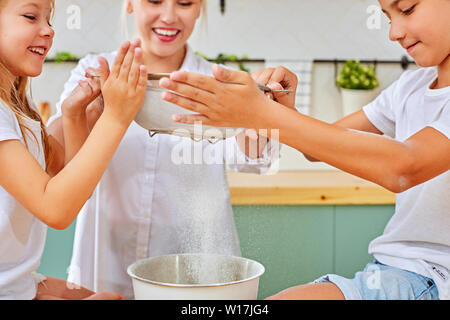 happy family mother and children son and daughter bake cookies Stock Photo