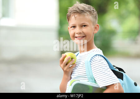 Little schoolboy eating tasty lunch outdoors Stock Photo