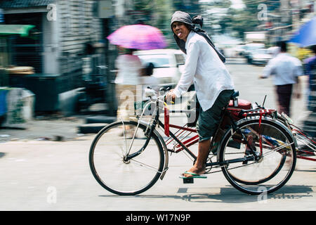 Yangon, Myanmar - March 2019: rickshaw man riding along the streets of Yangon. Stock Photo