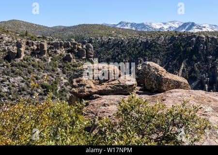 Rock pinnacles afford grand views of snow covered peaks and the valley below in Chiricahua National Monument in Southeastern Arizona. Stock Photo