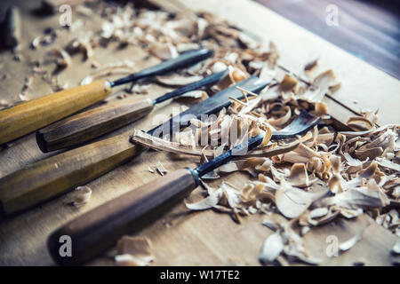 Woodworking vintage tools chisels with wood shawings on retro workbench Stock Photo