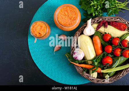 Delicious squash caviar in a jar on the table. Homemade caviar with zucchini, garlic, carrots, tomato sauce. Vegan cuisine. The top view. Flat lay Stock Photo