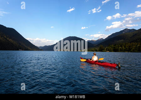 Woman kayaking at sunset in Weissensee Lake, Austria Stock Photo