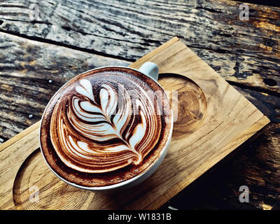 cup of coffee latte on dark wood table, beautiful latte art