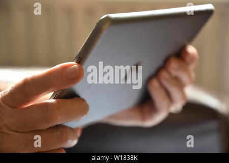 Close up of a senior woman holding an Apple iPad. Stock Photo