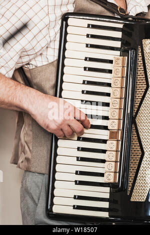 Live music background. Accordionist plays vintage accordion. Close-up vertical photo with selective focus Stock Photo