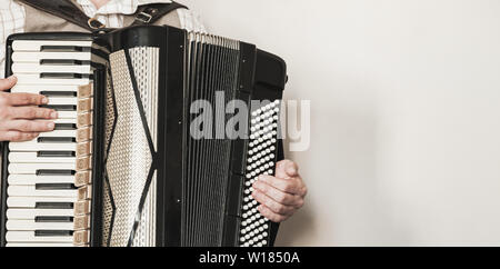 Vintage live music background. Accordionist plays retro accordion. Close-up photo with selective focus Stock Photo