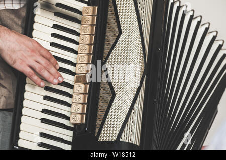 Live music background. Accordionist plays vintage accordion. Close-up photo with selective focus Stock Photo