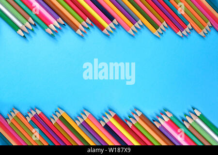 School concept. Creative composition of many color pencils on blue background. Flat lay, top view, copy space. Stock Photo