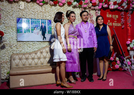 Two women pose for a photo beside the bride & groom at a traditional Khmer wedding ceremony in Siem Reap, Cambodia. Stock Photo