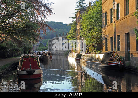 Narrow boats moored on Rochdale canal, Hebden Bridge, in evening light Stock Photo