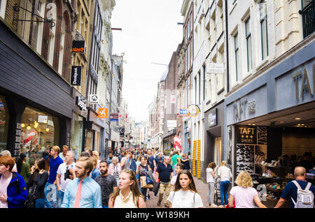 Amsterdam, Netherlands - June 12, 2016: People strolling around Kalverstraat on a cloudy spring day. Stock Photo