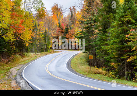 Winding Mountain Road trough a colourful forest in the Adirondacks in Autumn Stock Photo