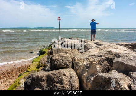 Boulders on Avon Beach at Mudeford in Dorset, UK , form a groyne to combat coastal drift and protect the beach. Stock Photo