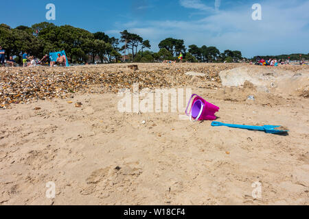 A child's toy bucket and spade abandoned on Avon Beach at Mudeford, Christchurch in Dorset, UK on a hot summer day, Stock Photo