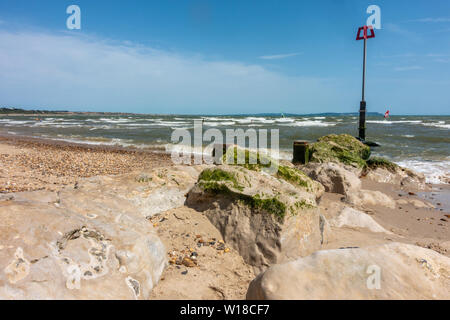 Boulders on Avon Beach at Mudeford, Christchurch in Dorset, UK , form a groyne to combat coastal drift and protect the beach. Stock Photo