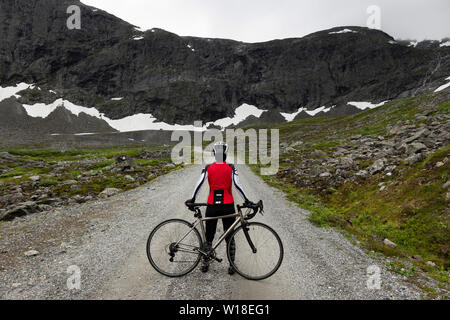 Female cyclist on private toll road through Vengedalen, close to Andalsnes, Norway. Stock Photo