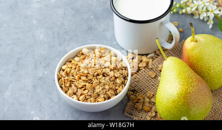Healthy eating or losing weight concept. Dry muesli (oat flakes) with fruit pear and milk. Stock Photo