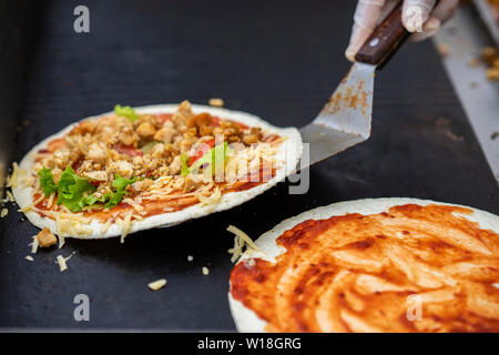 Hands cook making healthy fresh fajitas or fajitos with cheese, beef, tomatoes. Served very hot, from grill. Concept of national food Stock Photo