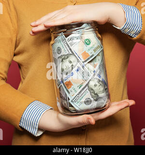 Cash us dollars in jar on colorful bright background. Saving money concept Stock Photo