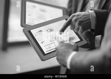 close up.two businessmen discussing financial data using a digital tablet. Stock Photo