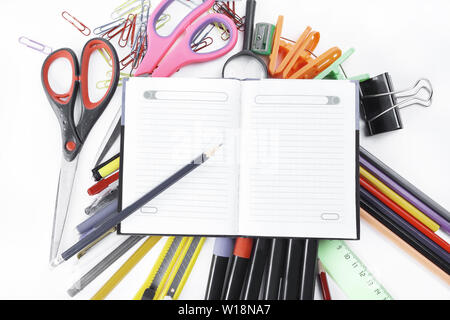opened Notepad on office supplies on white background. Stock Photo