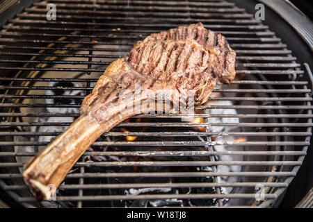 Beef tomahawk steak grilled on a grill - close-up Stock Photo