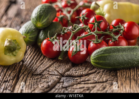 Fresh tomatoes cucumber and pepper on wooden table Stock Photo