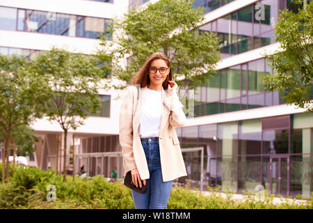 Shot of businesswoman looking at camera and smiling walking on the street. Stock Photo
