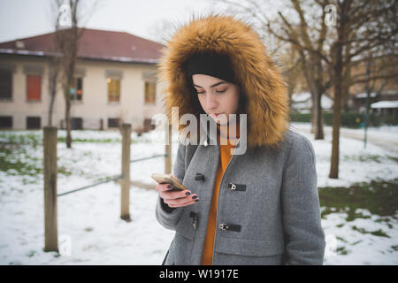 caucasian woman standing outdoor and using smart phone – technology, new generation, concentration Stock Photo