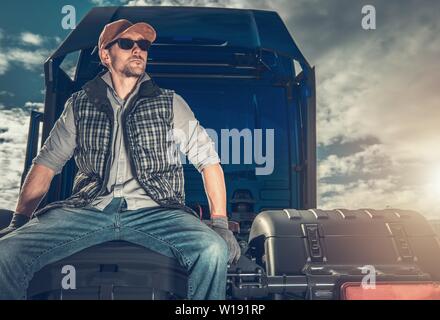 Relaxed Caucasian Truck Driver Seating on the Ground and Support His Back  on the Semi Truck Wheel Stock Photo - Alamy