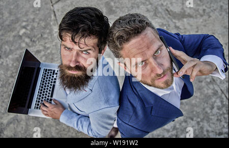 Entrepreneurship as teamwork. Businessmen with laptop and phone call solving problems making deal. Business experts support team, top view. Sales and online transaction. Sales department work as team. Stock Photo
