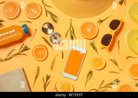 Smartphone mock up with summertime holiday vacation travel accessories on yellow background, flat lay top view Stock Photo