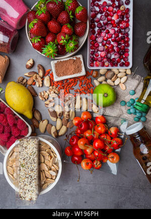 Super food to slow the ageing process concept including fruit, supplement powders, nuts, pills, berries. High in antioxidants, anthocyanins, dietary f Stock Photo