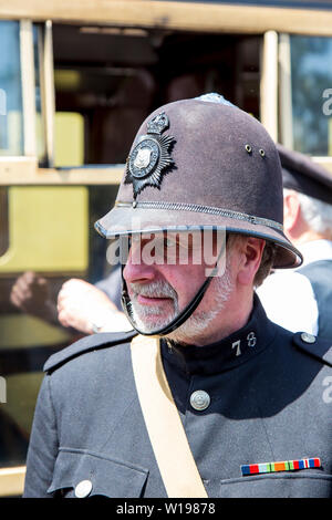 Kidderminster, UK. 29th June, 2019. Severn Valley Railway 'Step back to the 1940's' gets off to a fabulous start this summer weekend, re-enactors providing an authentic recreation of WWII wartime Britain during a difficult time of national crisis. A 1940s policeman (British bobby) in vintage helmet & police uniform stands on duty at Highley station - a vintage train station along this heritage railway line. Credit: Lee Hudson Stock Photo