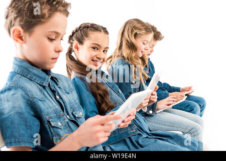 selective focus of four kids using digital tablets isolated on white Stock Photo