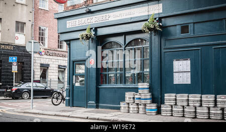 Dublin, Ireland - February 12, 2019 - beer barrels piled up on the street in front of an Irish pub on a winter day Stock Photo