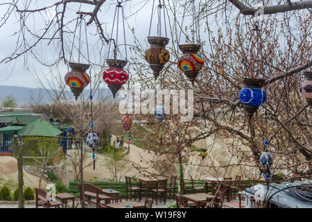 Turkish traditional colored glass craft lights on the branches of a tree close-up. Early spring, preparation for the tourist season in Cappadocia. Stock Photo