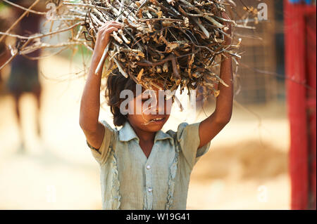 Child carrying firewood in Rohingya Refugee Camp Kutupalong, Bangladesh Stock Photo