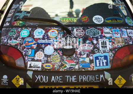 The rear of a Ford motor car covered in various colourful stickers. Stock Photo