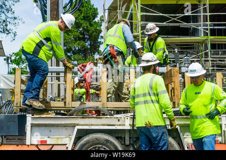 June 24, 2019 Mountain View / CA / USA - Team of construction workers wearing bright yellow vests and hard hats Stock Photo