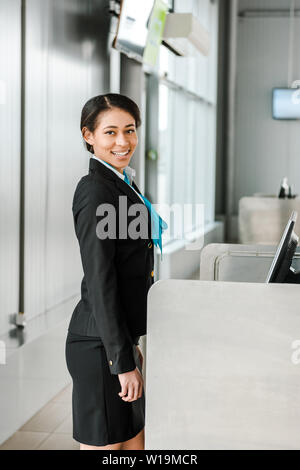 smiling african american airport staff in uniform standing at workplace Stock Photo