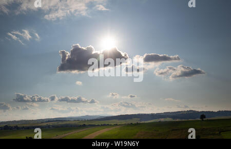 Hot day, the sun shining fiercely from behind the clouds Stock Photo