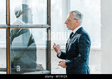 bearded businessman standing and talking with african american colleague Stock Photo