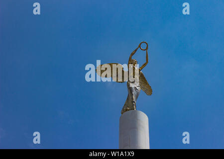 View at golden winged goddess woman holding wreath at a top of the monument to Fallen Heroes of Macedonia in Skopje, Northern Macedonia Stock Photo