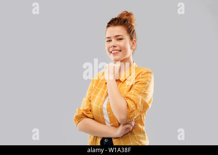 smiling red haired teenage girl in checkered shirt Stock Photo