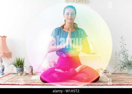 woman meditating in lotus pose at yoga studio Stock Photo