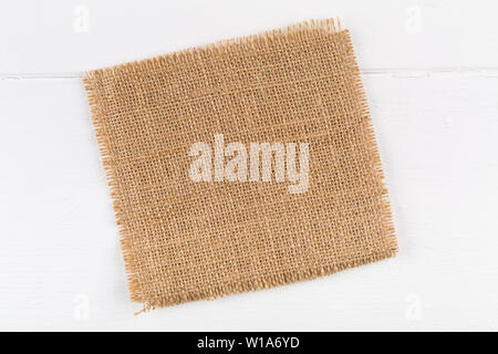 Burlap fabric cloth on white wooden kitchen table with copy space Stock Photo