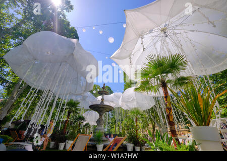 Zagreb, Croatia, July 1, 2019.  Lumen Station installation in Park. Outdoor pods in green city park, under squid like hanging umbrellas Stock Photo