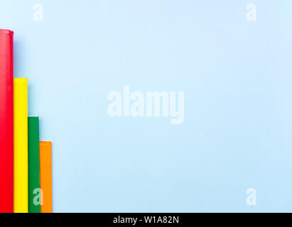 Bar chart made from colorful notebooks on light blue background with empty space for text. Stock Photo